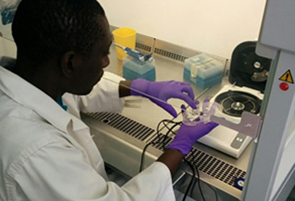 Dr. Cheikh Fall vom Institut Pasteur de Dakar / Senegal legt die LabDisk mit einer Blutprobe zum Test in das Analysegerät. © Benjamin Lopez-Jimena, University of Stirling / Großbritannien