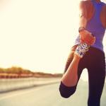Young,Fitness,Woman,Runner,Stretching,Legs,Before,Run,On,City